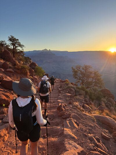 Grand Canyon adventure with group hiking along red rock trails at sunset.