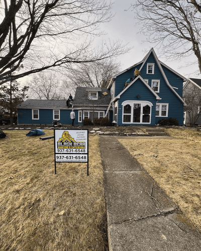 Front yard view of completed roof installation with Black Bear Roofing yard sign.