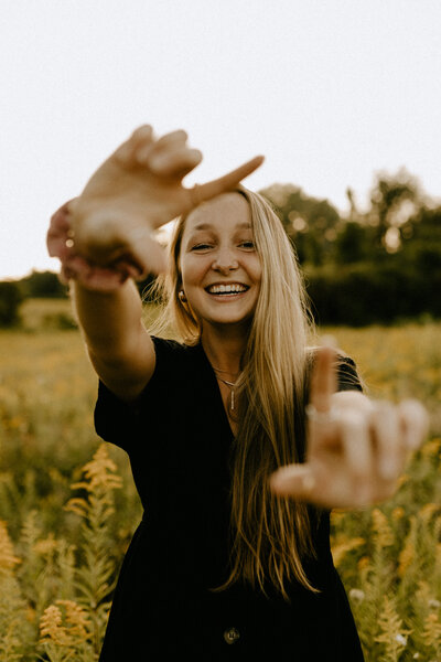 Girl laughing at the camera in a yellow field at sunset