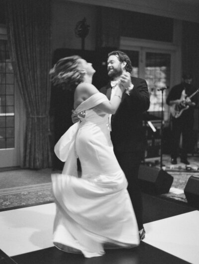 Seattle Wedding Photographers capture black and white film photo of bride and groom dancing at the historic Rainier Club 