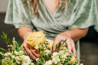 Woman sitting touching the flowers in her bouquet
