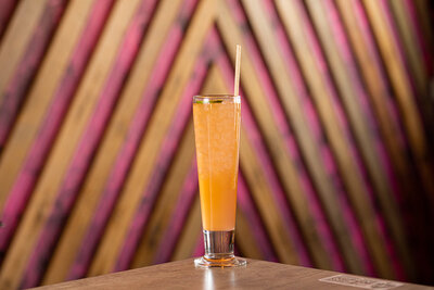 An orange margarita sits in front of a vibrant pink wall at Luna’s Tacos and Tequila in Greeley, Colorado.