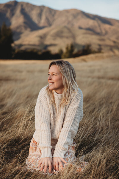 Bie sitting in the long grass  in Wanaka