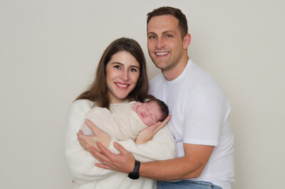 mom and dad family images with a wrapped baby