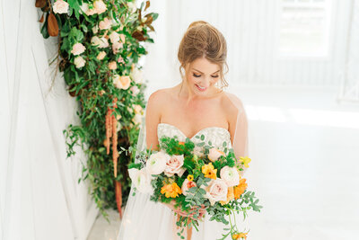 bride holding her bouquet in white barn wedding venue in idaho