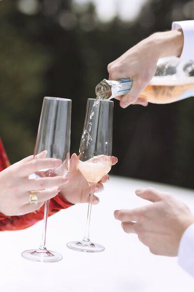 champagne is poured into glasses after a couple gets engaged on aspen mountain