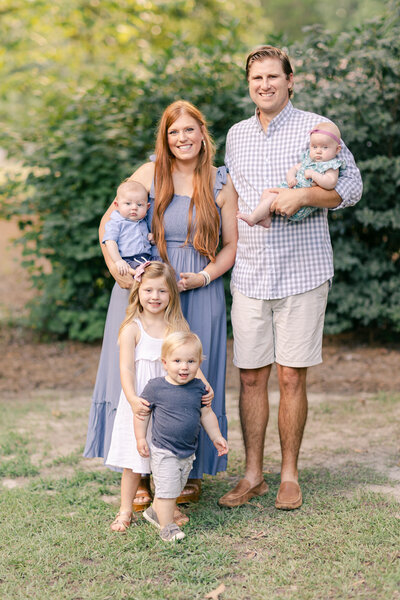 a young family of four smiles for a portrait for Auburn alabama family photographer