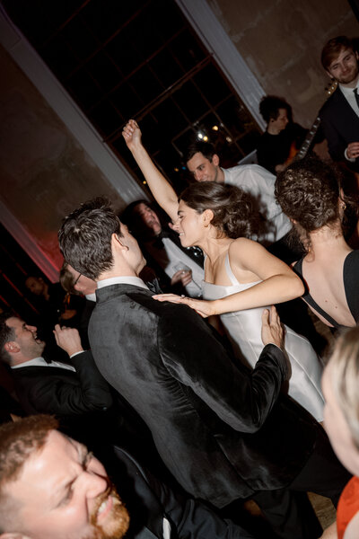 High-energy dance floor moment, with bride mid-twirl during final party hours.