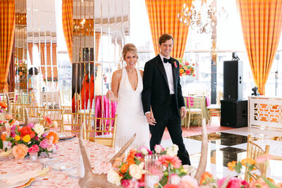 Candid image of a bride and groom walking together as they have their reception space reveal. They are both smiling and very happy in Forth Worth Texas