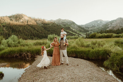 Mom is twirling while holding her baby boy in a field at  Palisades, Tahoe  City