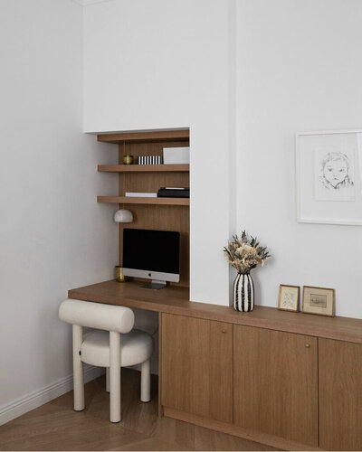 White room  with built-in wood millwork storage, desk and shelving