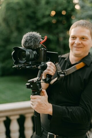 Indianapolis wedding videographer adjusting camera for ceremony scene.