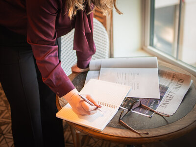 Anna Bradshaw writing content in a notebook on a table