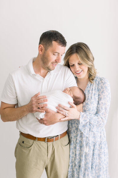 Mom and dad holding new baby at main line newborn session