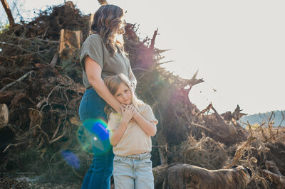 A child’s bare feet tucked up on a wooden chair, captured in soft black-and-white light during a quiet everyday moment.