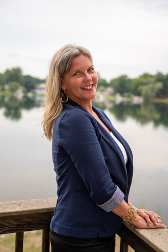 Jen Todd in a blue jacket next to a lake