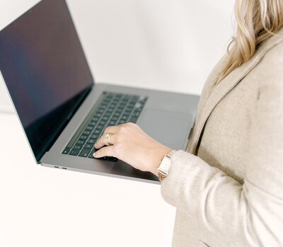 A woman holding a laptop.