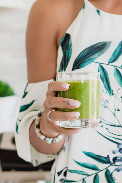 healthy woman holding green smoothie | web design for health and wellness entrepreneurs | BlairStaky.com