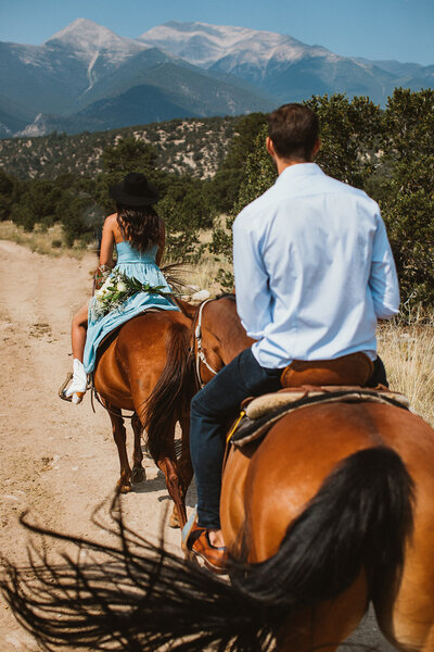bride and groom ride horses in Buena Vista