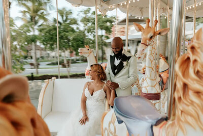Bride and groom laugh on merry-go-round in Garza Blanca