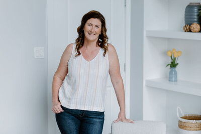 Michelle, founder of The Systems Café, standing confidently in a bright and welcoming space, symbolizing her approachable and professional style in helping entrepreneurs streamline their workflows and grow their businesses