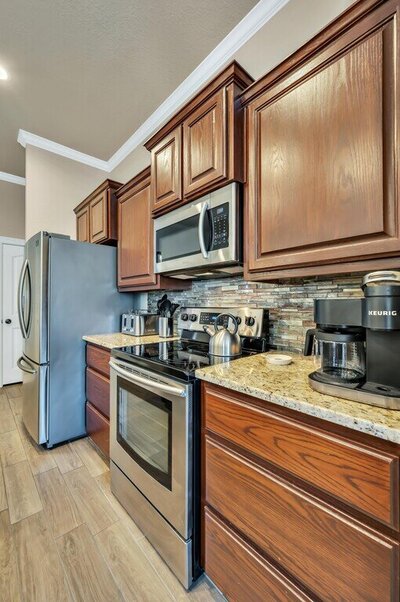 Kitchen with stainless steel appliances and granite counter tops in this three-bedroom, two-bathroom vacation rental lake house that sleeps eight just steps away from Stillhouse Hollow Lake in Belton, TX.