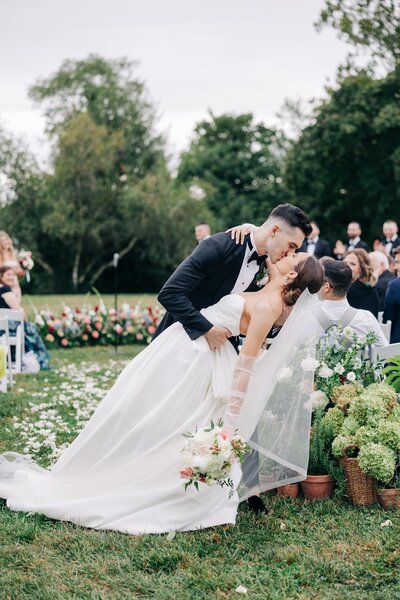 An elegant wedding reception setup with white floral centerpieces, transparent glassware, and chiavari chairs, captured by a luxury wedding photographer.