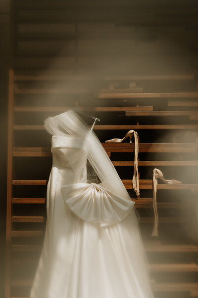 Elegant wedding dress and veil hanging at the Hyatt Regency Lisle in Illinois, photographed by Rainstorm Photo & Video with soft cinematic light for an intimate, documentary wedding story.