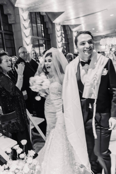 Best wedding photographer capturing a joyful grand exit as the newlyweds leave their Arizona wedding reception surrounded by cheering family.