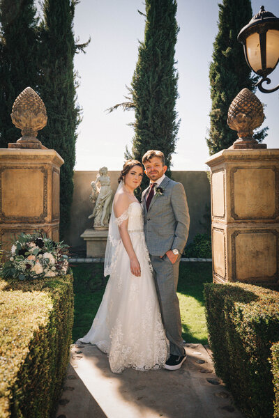 Bride and groom pose for portraits in grand garden