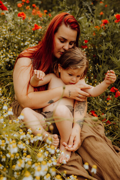 Moederschap fotoshoot tussen de bloemen in de natuu