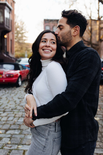 Couple posing in Troy, New York during their downtown engagement session
