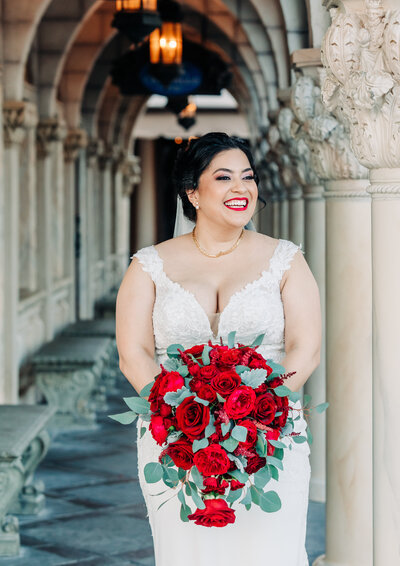 Bride portrait with red roses bouquet at Epcot for Disney's Fairytale Weddings