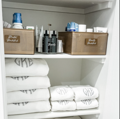 monogram white towels folded in linen closet