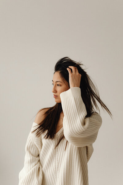 Stylish woman in cozy sweater representing ideal client for custom website design and branding services