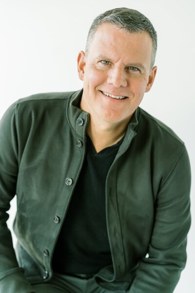 Man smiling against a light background.