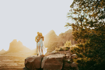 man standing with woman on red rocks