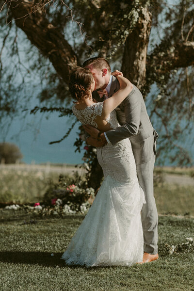 A bride and groom share a beautiful first dance on a terrace with breathtaking mountain views.