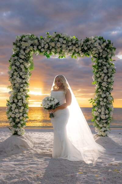 Backlit Bridal Portrait with full flower arch by Anna Maria Island photographer, Love and Style Photography