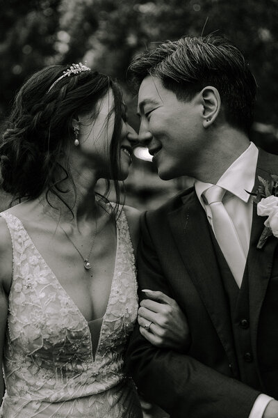 A black and white portrait of a couple smiling at gray bridge wedding venue