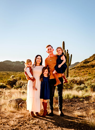 family of 5 posing and smiling for family photograph in Arizona