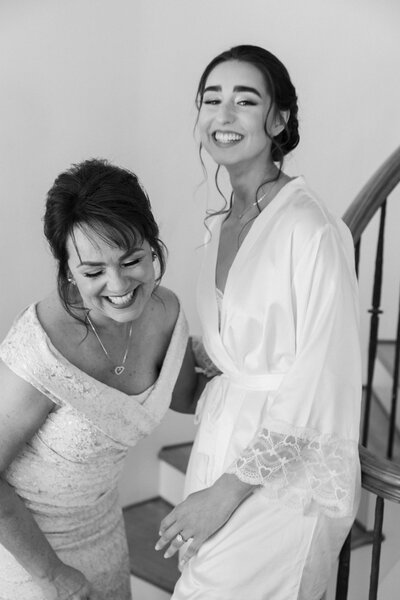 bride and mother of the bride laughing together