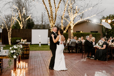 newlyweds dance under string lights
