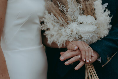 close up of bride and groom's hands showing wedding rings