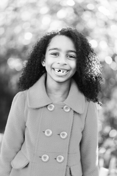 black and white photo of a girl missing a tooth