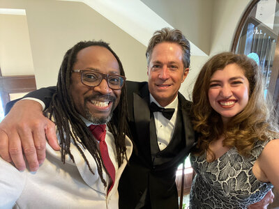 Three people smiling in formal attire
