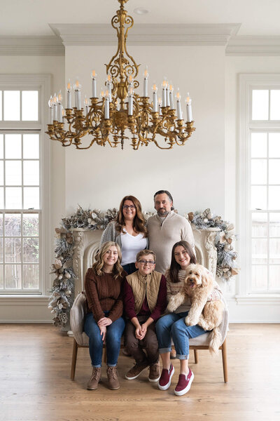 family smiles at the camera during a Christmas mini session at the Creative Chateau in Houston Texas
