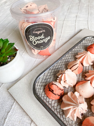 Blood orange meringues drizzled with chocolate