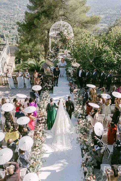 Elegant bride and groom standing hand in hand in a sunlit stone courtyard in the Chateau St Georges South of France — Portfolio Thomas Raboteur Wedding Photographer.