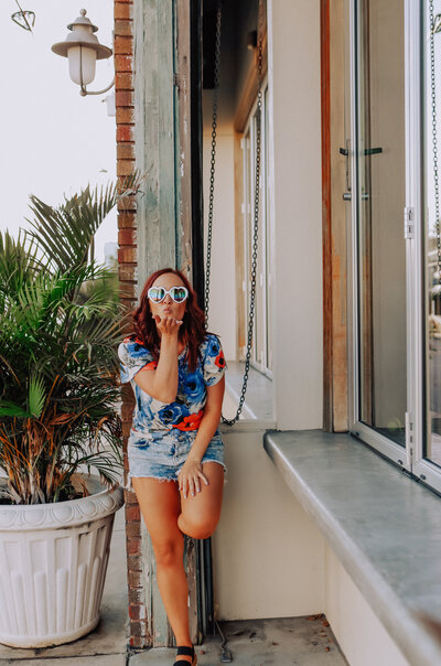 girl wearing heart sunglasses blowing kiss at camera